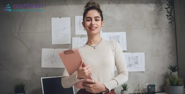 A smiling woman holds a clipboard in an office setting, representing Business Administrative Assistants at Northwest Career.