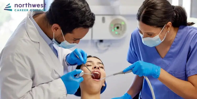 A dentist and dental assistants work together to examine a patient in a dental office setting.