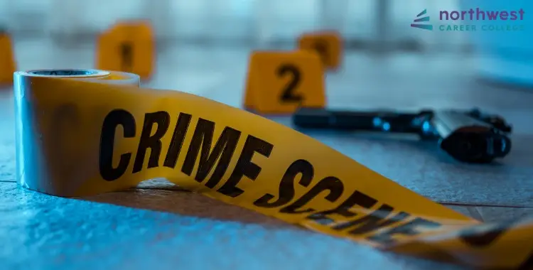 Crime scene tape and evidence markers near a firearm, highlighting the importance of Crime Prevention Strategies.