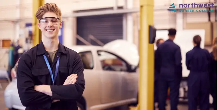 Smiling student in a workshop setting, reflecting on What Are Trade School Pros and Cons in automotive training.