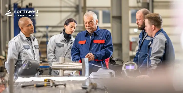 A group of five people in work attire discussing a project in a workshop setting.