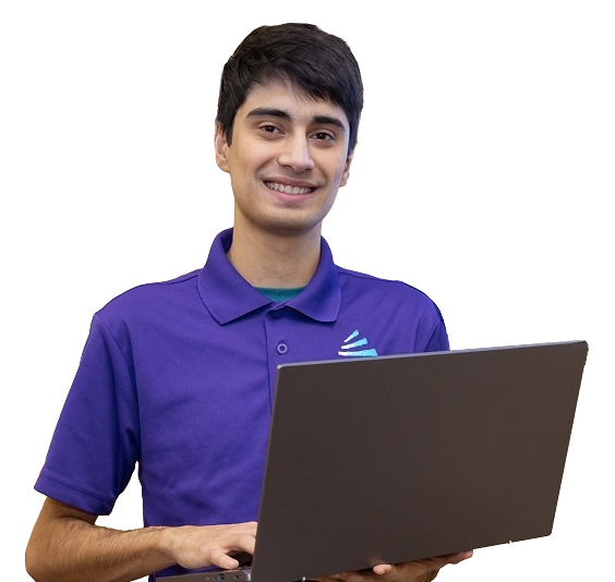 A smiling student in a purple shirt holds a laptop, representing an it technician school environment.