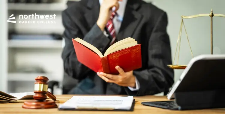 A professional holding a book in an office setting, symbolizing the transition from Paper Cuts to E-Filing in legal work.