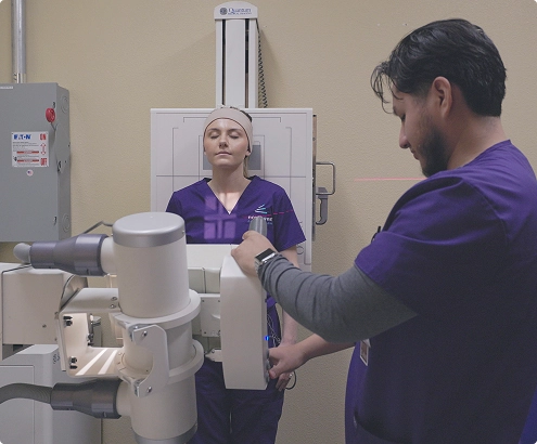 A student practices X-ray techniques at an X-ray technician school in Las Vegas, preparing a patient for imaging.