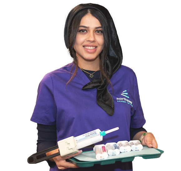 A smiling student in a purple shirt holds dental tools, showcasing skills learned at dental assistant school.